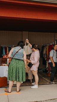 Guests of St. Jacobs Market Open Air Antique Fair browsing in a clothing booth 