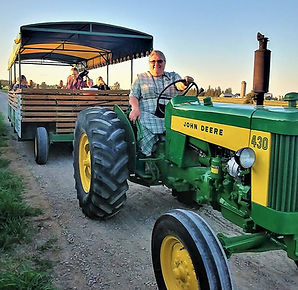 a tractor pulling a people mover trailer taking guests on a tour 