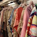 - A clothing rack with tie-dyed clothing hanging by Blue Dream Designs