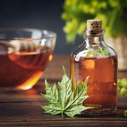 Bottle of maple syrup or healthy tincture and spring maple leaf. Bowl of maple syrup and w