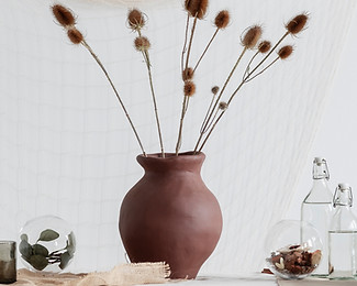 Clay Vase filled with thistles on a table with other decorative vases showcasing products from St. Jacobs Outlet Mall