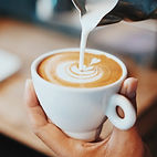A barista pouring milk to create latte art 