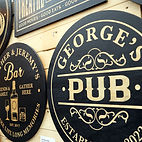 Several signs displayed on a wood wall at Grand Impressions