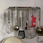 Several kitchen tools hanging on a wall from Triple A Trading 