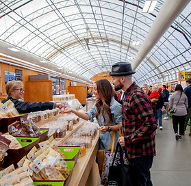 A couple purchasing goods from a vendor inside the Market Tent Building of St Jacobs Market 