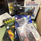 A stack of DVDs, CDs, and VHS tapes at Discount Video Plus 