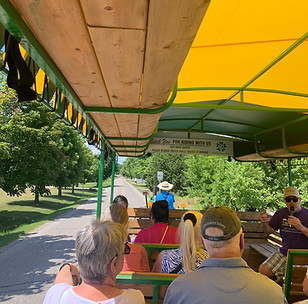 Several Guests enjoying a scenic tour in a covered wago pulled by tractor with Elmira Wagon Rides Country Tour 