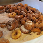 Mini Donuts being tossed in cinnamon sugar at Lil' Donuts 