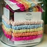 a glass jar filled with satin scrunchies mad by Liv Lush 