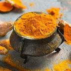 A small decorative bowl filled with turmeric from Tumerix