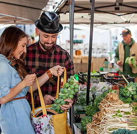 a young couple shopping for Brussel Sprouts 