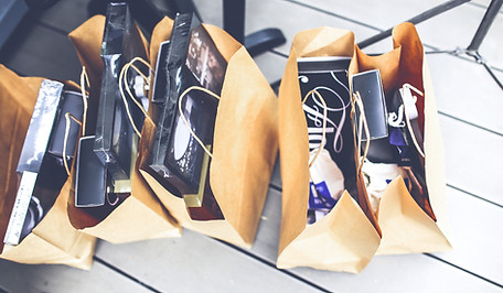 a black and white image of shopping bags filled with merchandise sitting on a wood floor 