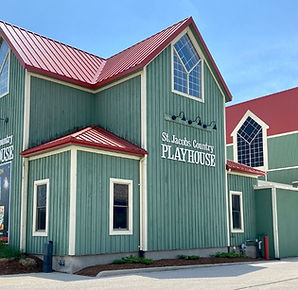 Sideview of a green building with a red roof with text overlay "St. Jacobs Country Playhouse"