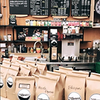 A selection of coffee beans packaged in front of a coffee bar at Full of Beans Coffee Bar